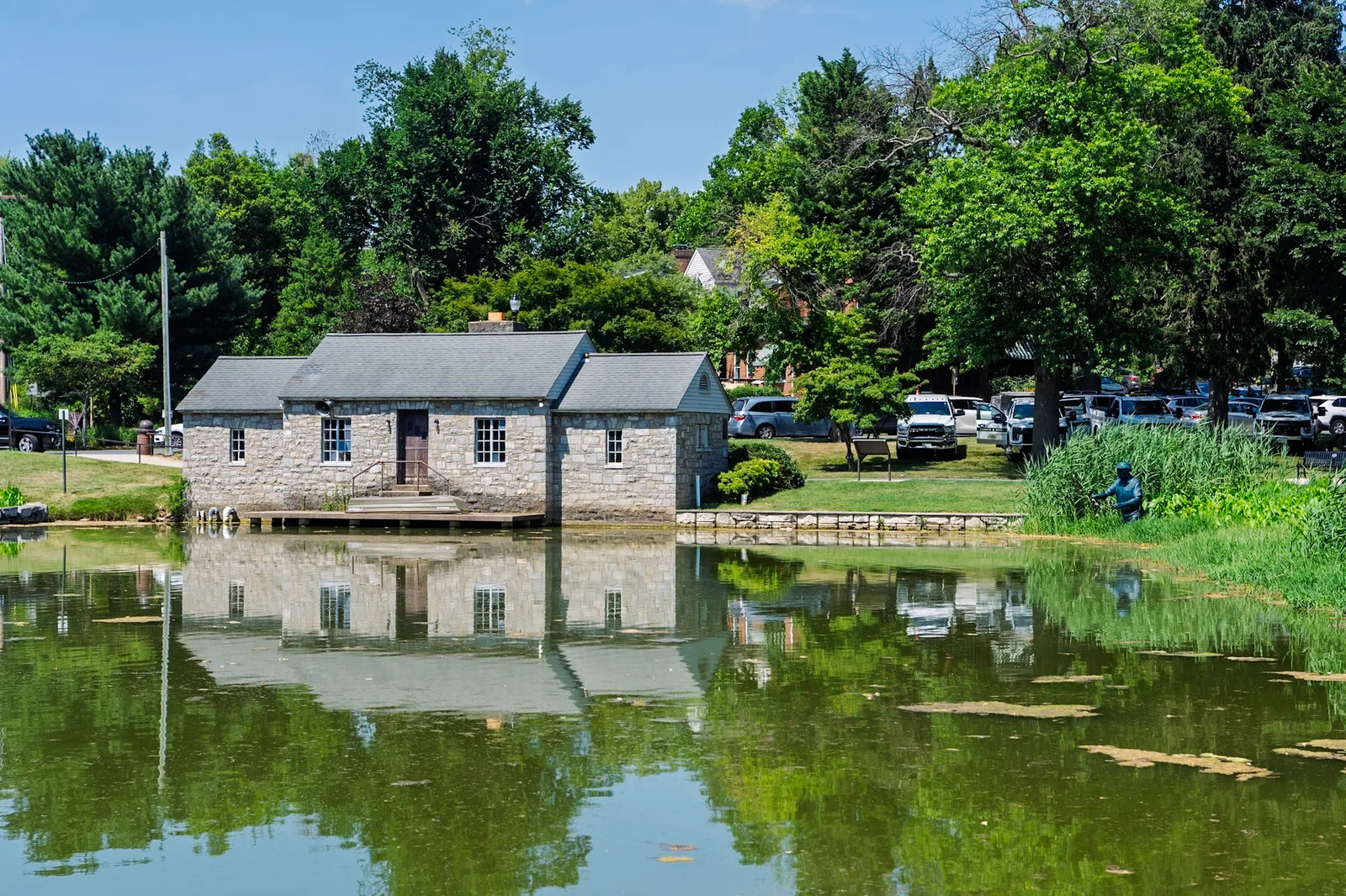 A historic stone building reflected in a still pond