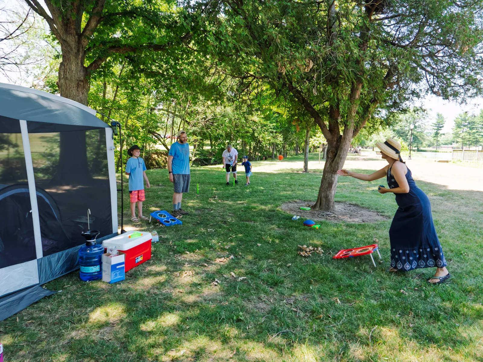 The whole crew playing cornhole and horseshoes on the grass by our tent