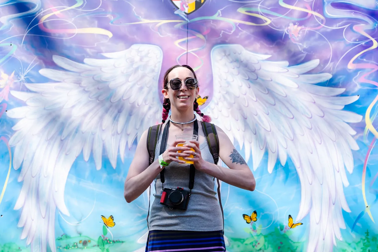 Girl in Pigtails at the angel wings mural, camera around her neck