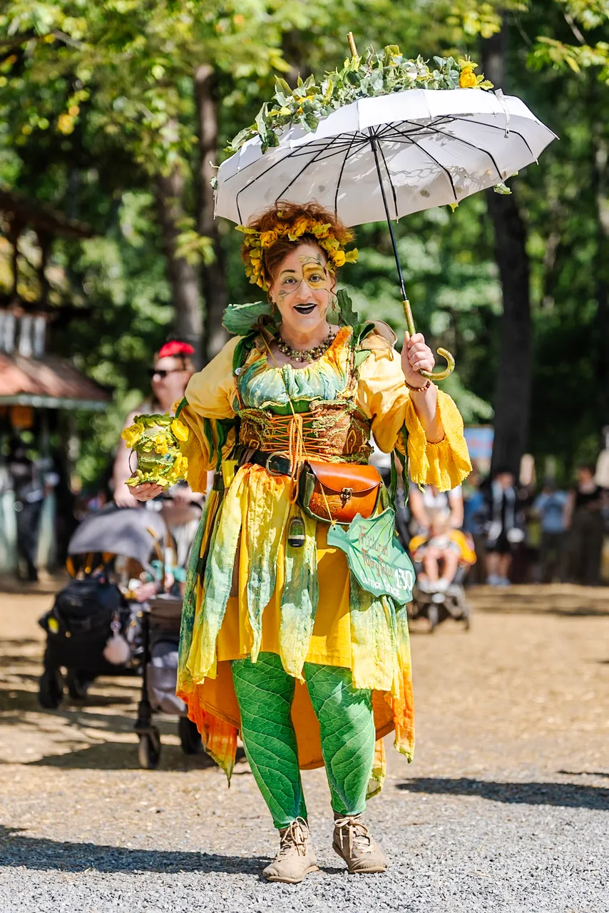 A performer in green and gold twirling a white parasol