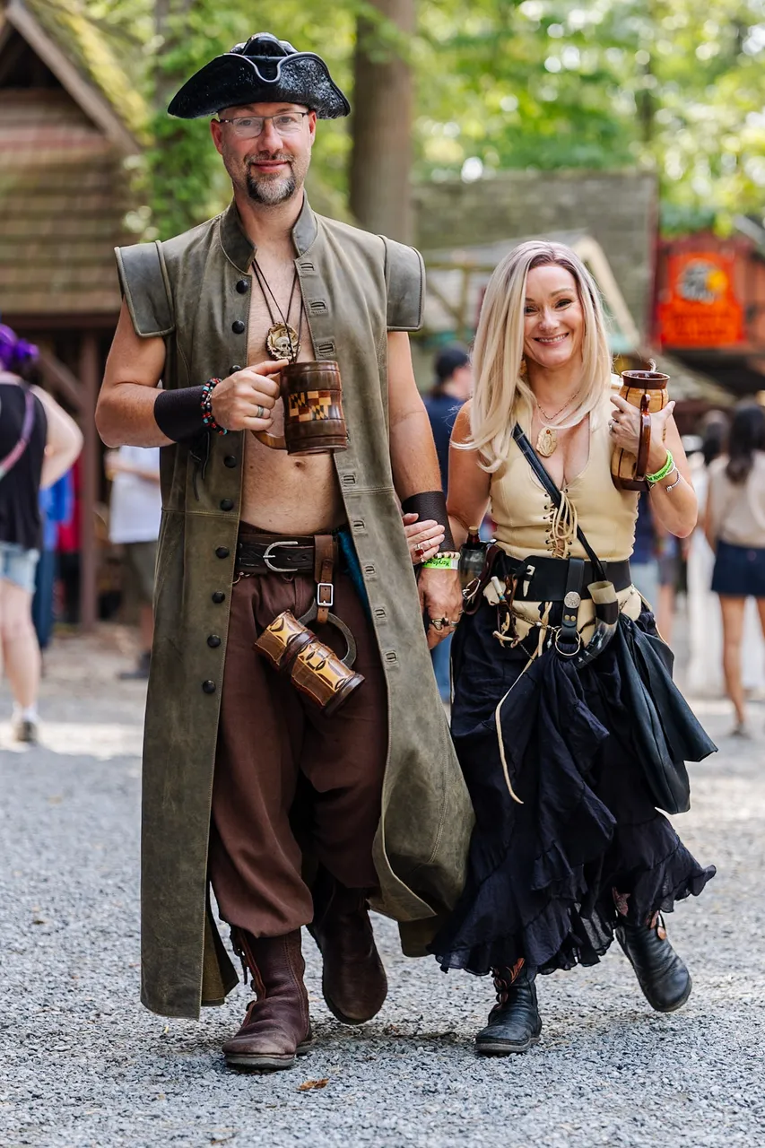 A pirate couple strolling the lanes with drinks in hand